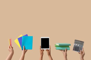 Bej arkaplan üzerinde boş tablet bilgisayarı, kitapları ve hesap makinesi olan kadınlar