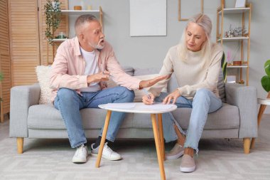 Olgun bir çift evde boşanma fermanını imzalıyor.