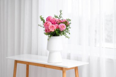 Oturma odasındaki masada duran güzel pembe yıldız çiçekleri.