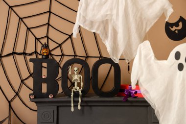 Şenlikli oturma odasında haber bülteni ve Cadılar Bayramı süslemeleri olan şömine rafı, yakın plan.