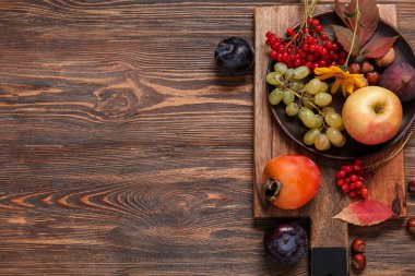 Ahşap arka planda farklı taze meyveleri olan tahta.