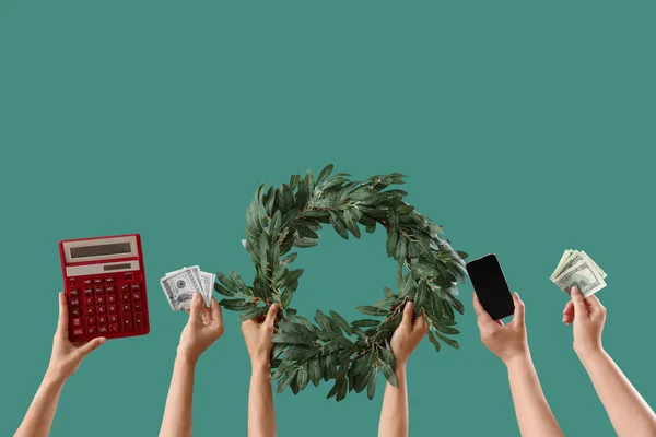 Women with mobile phone, money, calculator and Christmas wreath on green background