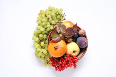Beyaz arka planda farklı taze meyveler, böğürtlenler ve balkabağı var.