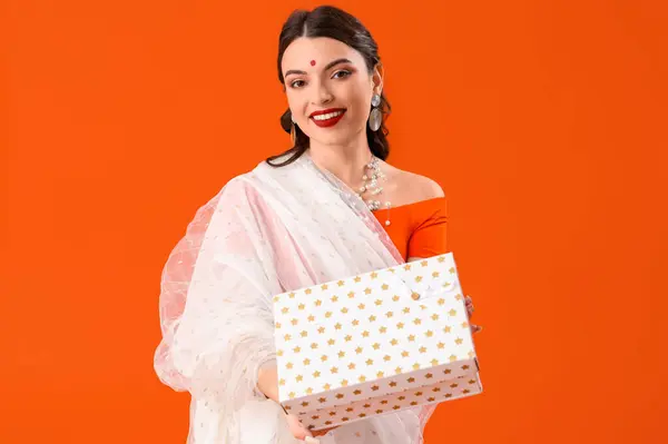 Hermosa Joven India Sari Con Caja Regalo Sobre Fondo Naranja — Foto de Stock