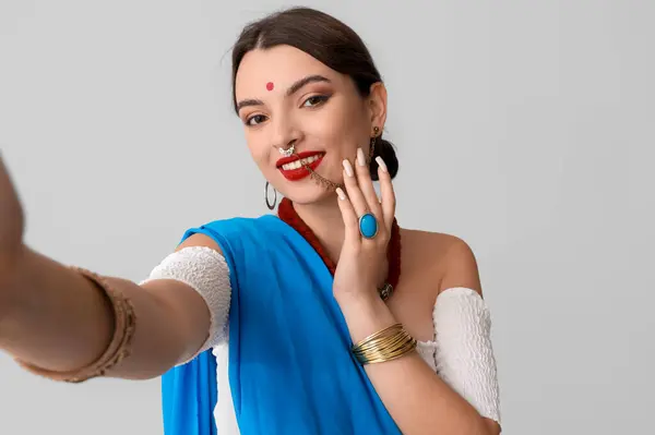 Hermosa Joven India Sari Tomando Selfie Sobre Fondo Gris — Foto de Stock