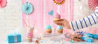 Bir kadın masadan lezzetli kekleri alıyor. Bebek teşhir partisi