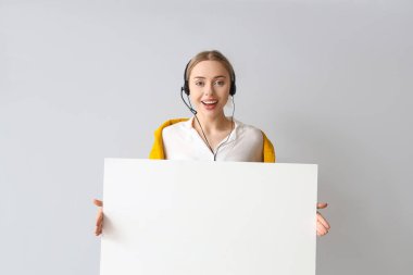 Işık arka planında boş posteri olan kadın teknik destek ajanı