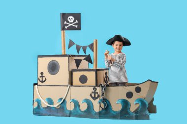 Mavi arka planda karton gemide dürbünü olan sevimli küçük bir korsan.