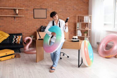 Pasaportlu ve yüzme yüzüklü genç işadamı yaz tatiline hazır.