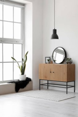 Ayna, ahşap dolap ve büyük pencereli ışık koridorunun içi.