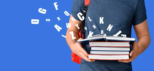 Student with books and English letters on blue background