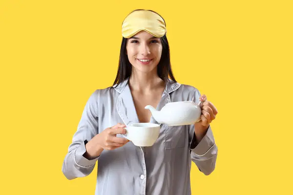 Young Woman Pajamas Pouring Tea Cup Yellow Background — Stock Photo, Image