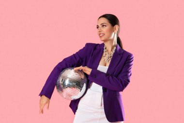 Pembe arka planda disko topu olan şık genç bir kadın.