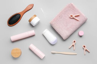 Gri arka planda farklı kozmetik ürünleri ve banyo malzemelerine sahip kompozisyon