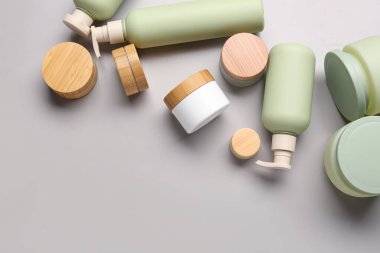 Gri arkaplanda farklı kozmetik ürünleri seti