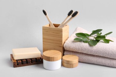 Gri arka planda banyo malzemeleri ve kozmetik ürünleri.