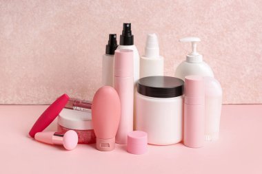 Pembe arka planda farklı kozmetik ürünleri seti