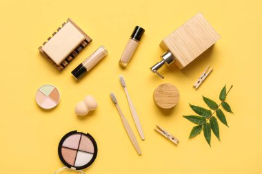 Renkli arka planda farklı kozmetik ürünleri ve diş fırçaları içeren kompozisyon