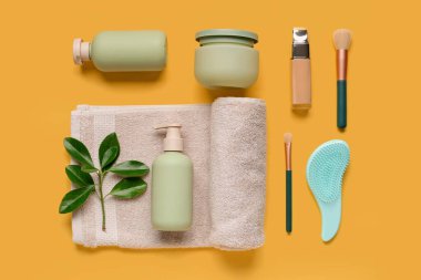 Sarı arka planda banyo malzemeleri ve kozmetik ürünleri içeren kompozisyon