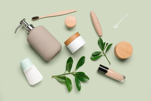 Composition with different cosmetic products and plant branches on color background