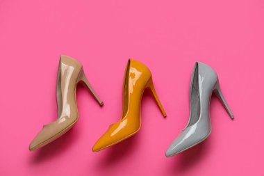 Pembe arka planda farklı yüksek topuklu ayakkabılar.
