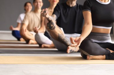 Spor salonunda meditasyon yapan bir grup genç, yakın plan.