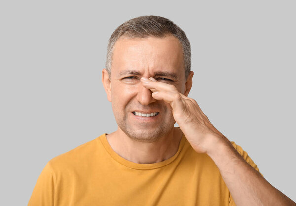 Ill mature man on grey background