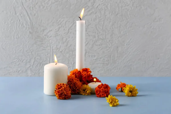 Burning candles with marigold flowers on color background. Celebration of Mexico's Day of the Dead (El Dia de Muertos)