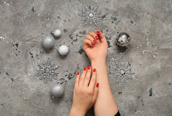 Vrouwelijke Handen Met Rode Manicure Zilveren Kerstballen Grijze Grunge Achtergrond — Stockfoto