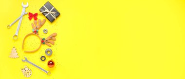 Yılbaşı hediyeli inşaat araçları ve sarı arka planda metin için alanı olan dekorasyon araçları