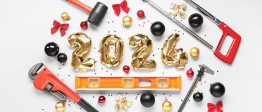 Builder's supplies with Christmas decor and balloons in shape of figure 2024 on white background clipart