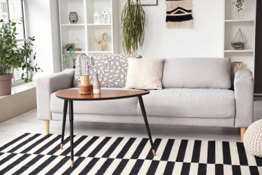 Gri kanepesi ve kahve masası olan şık bir oturma odası.