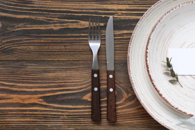 Kahverengi ahşap arka planda kartı olan modern masa ayarları