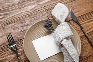 Kahverengi ahşap arka planda kartı olan modern masa ayarları