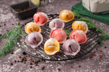 Renkli çiğ hamur köfteleri, biberli ve dereotlu koyu arkaplan.