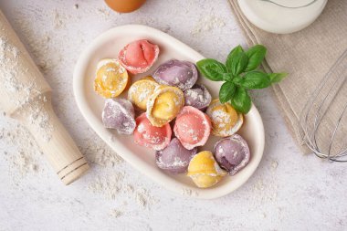 Renkli çiğ hamur köftesi ve beyaz arka planda fesleğen.