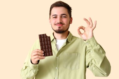Lezzetli çikolatalı genç adam bej arka planda iyi görünüyor.