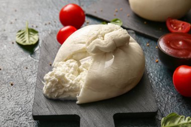 Mavi arka planda lezzetli Burrata peyniri olan tahta