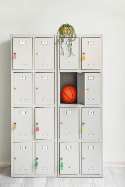 Işık duvarının yanında top ve bitki dolu modern bir dolap.