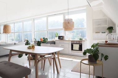 Mutfağın içinde yemek masası ve tezgahları var.