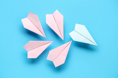 Mavi arkaplanda renkli origami kağıt uçaklar