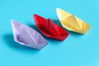 Mavi arkaplanda renkli origami tekneleri