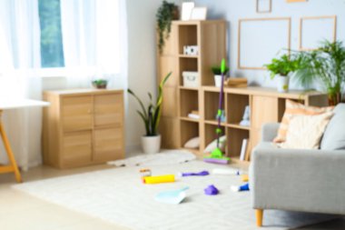 Bulanık oturma odası, raflar ve temizlik malzemeleri.