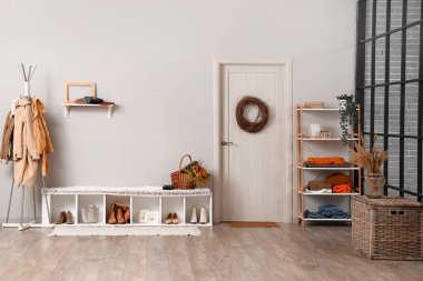 Modern koridorun içinde şık kıyafetler, ayakkabılar ve sonbahar süslemeleri var.