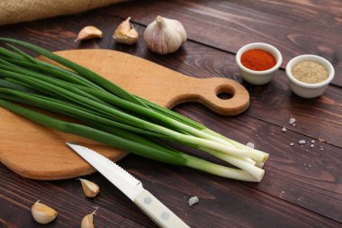 Ahşap zemin üzerinde taze yeşil soğan olan tahta.