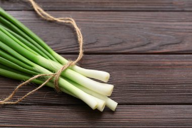 Ahşap arka planda taze taze soğan, yakın plan.