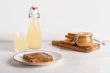 Beyaz arka planda fıstık ezmeli bir tabak tost.