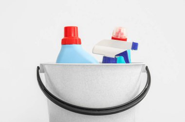 Beyaz arka planda temizlik malzemeleri olan plastik bir kova.