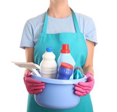 Temizlik işçisi elinde plastik kaseyle beyaz arka planda temizlik malzemeleri tutuyor.