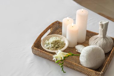 Spa composition with burning candles on couch in salon, closeup